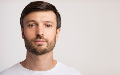 Portrait Of Confident Man Posing Over White Studio Background