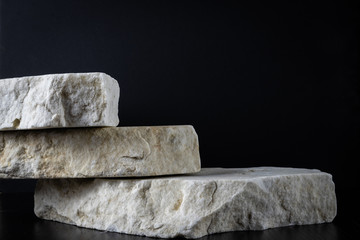 3 white marble rough stones on a black background © Bar