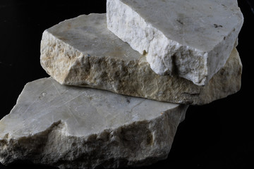 3 white marble rough stones on a black background