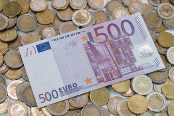 Ein 500 EURO Geldschein liegt auf einem Haufen EUR-Münzen
