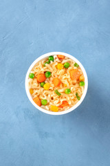 Ramen cup, instant soba noodles with vegetables in a plastic cup, overhead shot with copy space