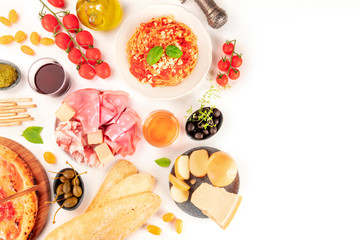 Italian food. Pizza, pasta, cheese, hams, olives and olive oil, tomatoes, wine, basil, shot from the top on a white background with a place for text, a flat lay composition