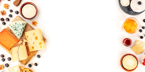 Cheese board, a flat lay panoramic top shot on a white background with copy space. Blue cheese, Leicester, Emmental, Brie, and others sorts with wine and fruits, forming a frame with a place for text