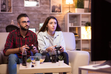 Beautiful young couple having fun playing video games