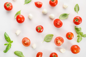 Naklejka premium Ripe red cherry tomatos and mozzarella on white background. Top view