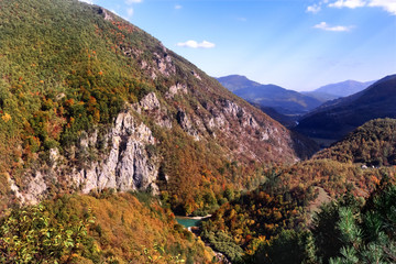  Amazing mountain autumn landscape with colorful forest. Fall  cold colors trees in the Montenegro mountains. Yellow, orange, burgundy trees in the mountains.Mountain horizon.