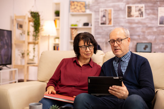 Beautiful old couple using a digital tablet to chat with their family