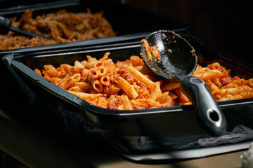 Macaroni and tomato sauce ready to serve. Image of prepared catering food at the time of serving the dishes