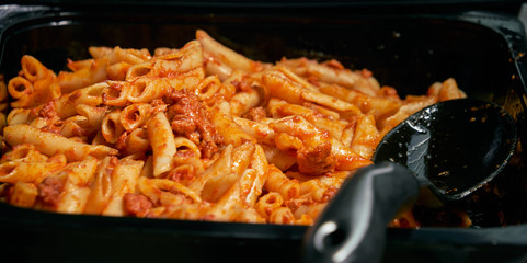 Macaroni and tomato sauce ready to serve. Image of prepared catering food at the time of serving the dishes