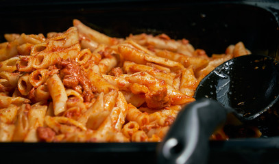 Macaroni and tomato sauce ready to serve. Image of prepared catering food at the time of serving the dishes