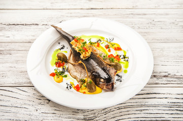 Fish and salad in a restaurant close-up. Dorado on a white plate and copy space.