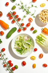 Healthy salad ingredients on white background in hard sun light with harsh shadows. Vegan meal. Pattern isolated