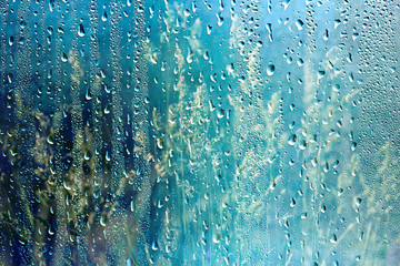 summer rain wet glass / abstract background landscape on a rainy day outside the window blurred...