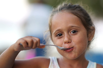 4 year old girl eating and smiling.