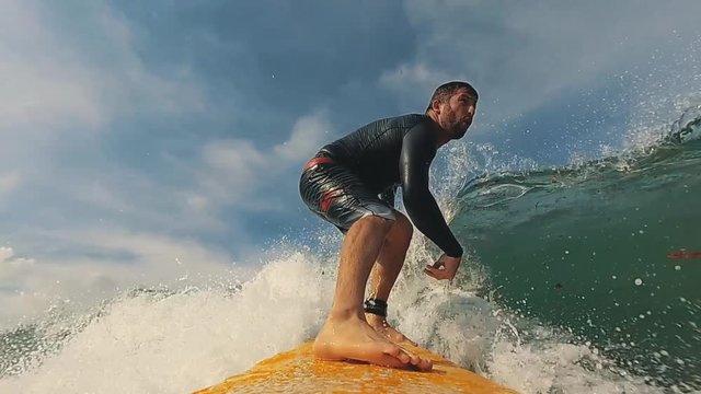 Male surfer getting ready for ride on the ocean wave against beautifull sinset light