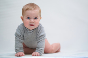 a six-month-old baby learns to crawl. emotional portrait of a child