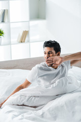 handsome bi-racial man yawning and waking up in morning