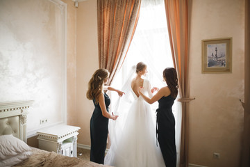 Hands of bridesmaids on bridal dress. Happy marriage and bride at wedding day concept