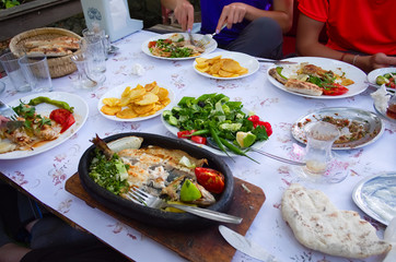Plates with different Turkish food in a restaurant in a small village in mountains. Big variety of traditional local cuisine on table. Traditioanl Turkish dinner meze. Turkey.