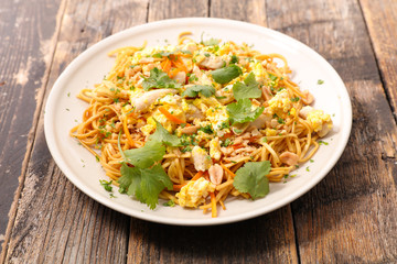 fried noodles with fried egg, peanut, vegetable and coriander