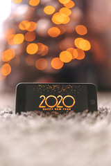 2020 on the phone, against the background of bokeh, new year 2020