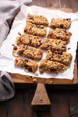 homemade granola bar with nuts, cranberry,cereal on wooden board