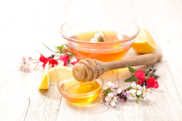 Obraz na płótnie Canvas bowl of floral honey with lemon and flowers