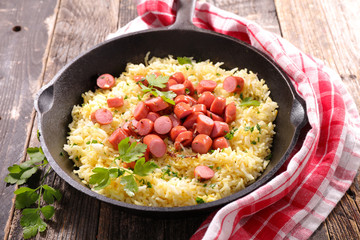 rice and sausage in cooking pan