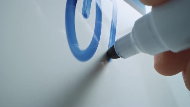 Macro Follow Shot of a Blue Marker Pen Being Held with a Hand. Person Writing on a Whiteboard with Graphs and Business Plans. Pencil is Connected to the Camera. Gripped Shot. Writing "OK".
