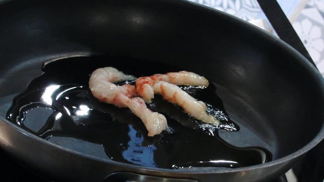 The langoustes are fried in a frying pan in the kitchen
