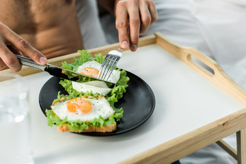 cropped view of bi-racial man having breakfast in morning