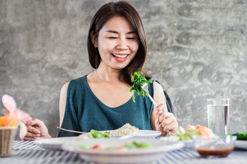 Happy Asian woman eating healthy food and green vegetables 