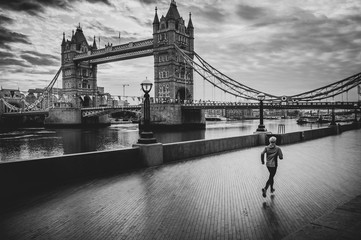 London lifestyle man running near Tower Bridge. Male runner jogging training in city