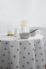light dishes on the table, restaurant. white tablecloth with a pattern of circles, on a light background.