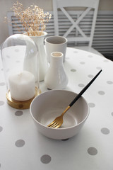 Fototapeta na wymiar тарелки на столе с белой скатертью, сервированный стол, интерьер квартиры