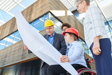 Ingenieur Team mit Bauplan und Architektin im Rollstuhl