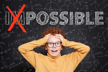 Confident smart kid with text possible on chalkboard background. Success and develop concept