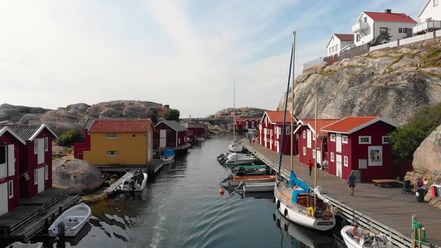 Low altitude drone flight over canal with docked boats in Smogen, Bohuslan in Sweden