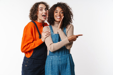 Portrait of surprised multinational women pointing finger aside