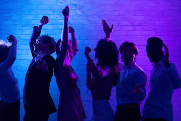Fototapeta na wymiar Cheerful Young People Dancing Having Fun At Night Party Indoor