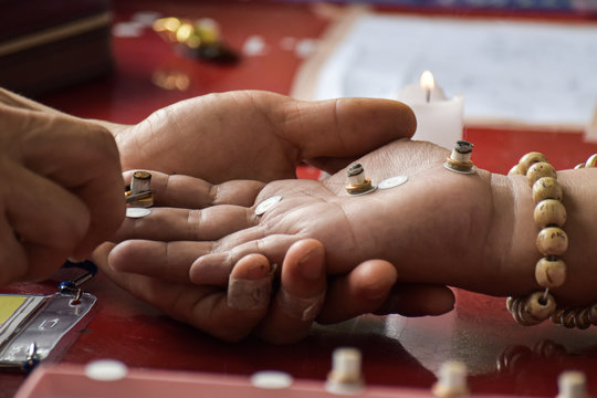 Close-up of fortune teller with candles on the palm. Ancient healing