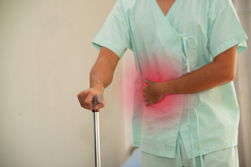 The male patient had a stomach ache and walked into the room using a walking stick as an anchor....