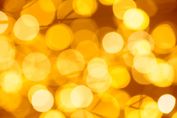 Background of golden bokeh lights. Defocused abstract gold blurred lights