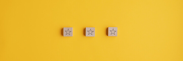 Three wooden blocks with star shape on them placed in a row - obrazy, fototapety, plakaty