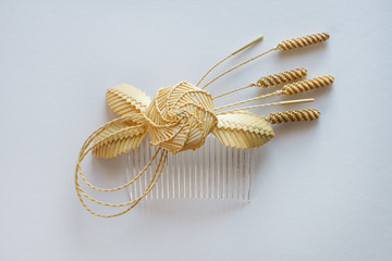 Ornamental hair comb with straw flowers on a white background