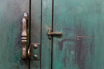 Vintage handle on a well worn metal locker with paint scratches