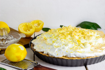 Lemon pie with meringue on a wooden background.