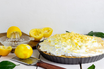 Lemon pie with meringue on a wooden background.