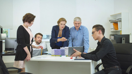 Obraz premium Engineer in glasses show something on tablet to his workmates