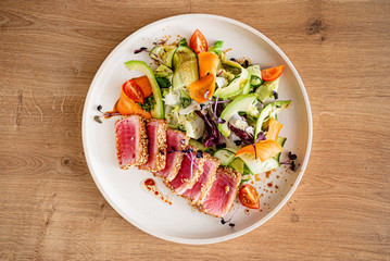 tuna steak with fresh salad on teh wooden background